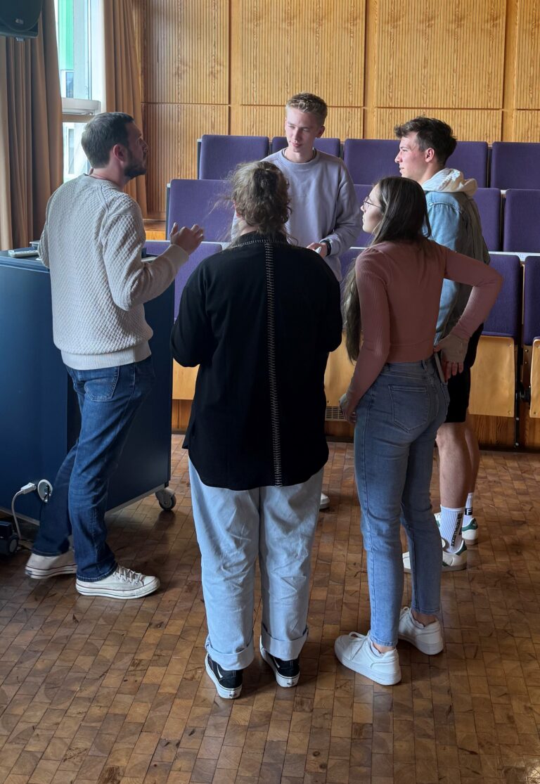 4 Schülerinnen und Schüler im Gespräch mit dem Referenten von Fulbright Germany