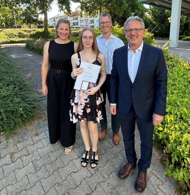Preisträgerin mit Klassenleitung und Schulleitung vor dem Schulhaus